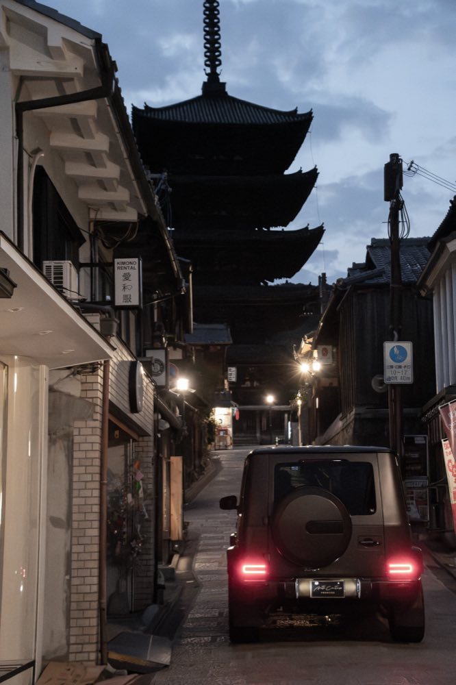 夕暮れの京都・東山、八坂の塔（法観寺）へ続く石畳の路地を走るマットブラウンのメルセデス・ベンツ Gクラス（FOURSIDE）